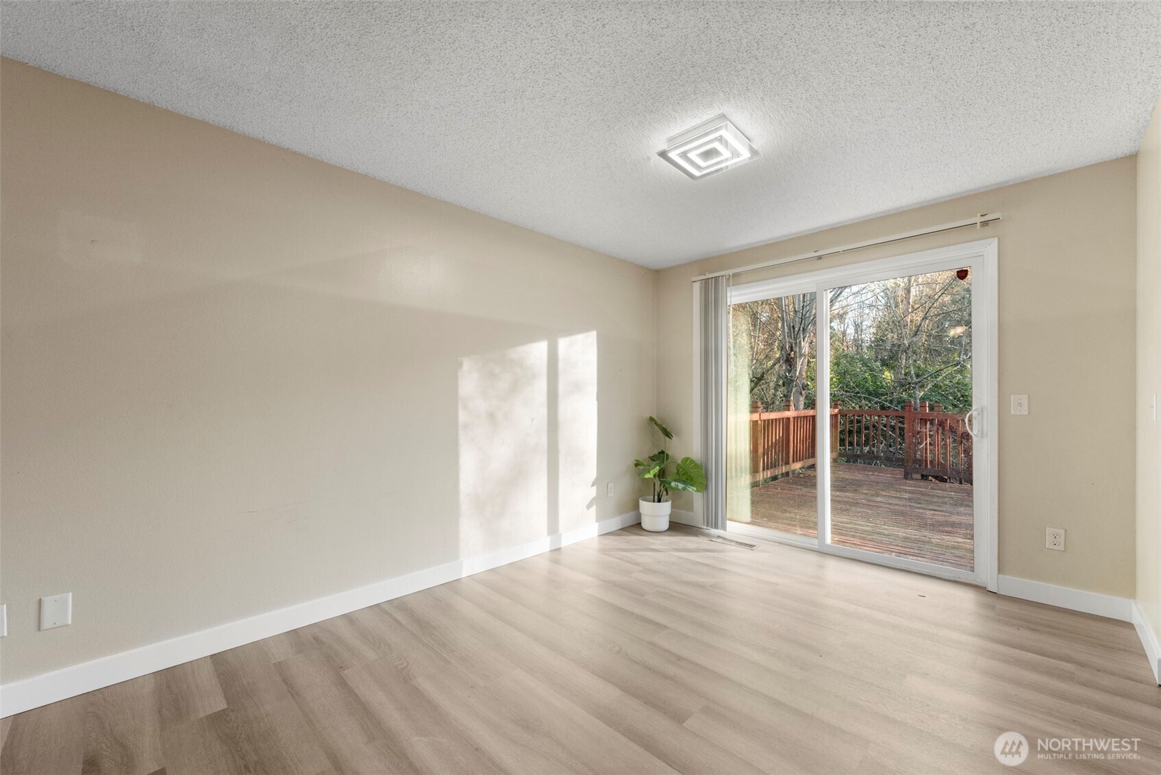 12727 Southeast 191st Place Renton, WA 98058 - Photo 6 of 23 a view of an empty room with wooden floor and a window