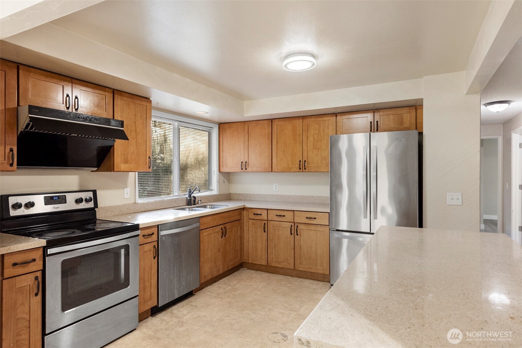 12727 Southeast 191st Place Renton, WA 98058 - Photo 8 of 23 a kitchen with stainless steel appliances a stove sink microwave and refrigerator