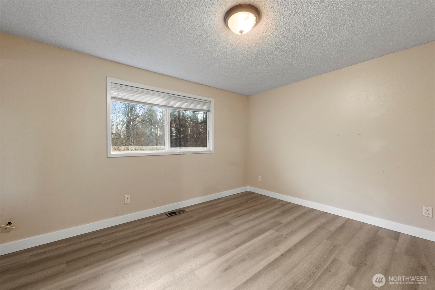 12727 Southeast 191st Place Renton, WA 98058 - Photo 10 of 23 an empty room with wooden floor and windows