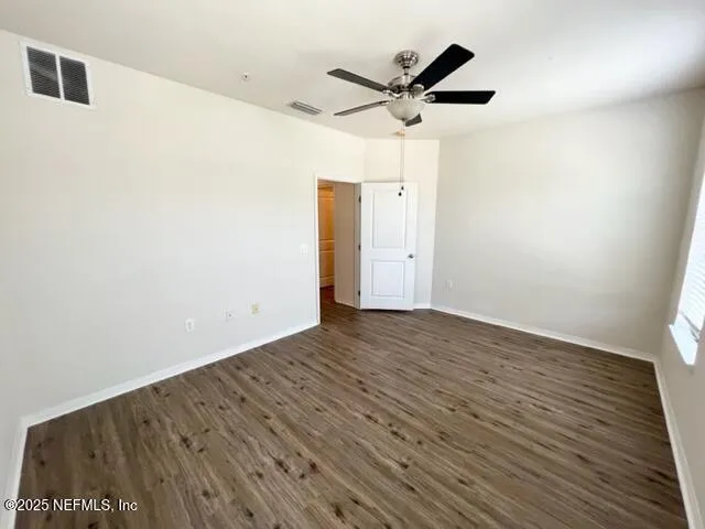 a view of a big room with wooden floor and windows
