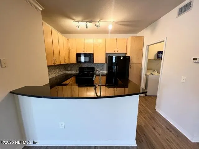 a kitchen with stainless steel appliances granite countertop a refrigerator a stove and a sink