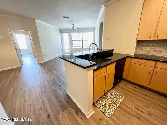 a kitchen with granite countertop a sink and wooden floor