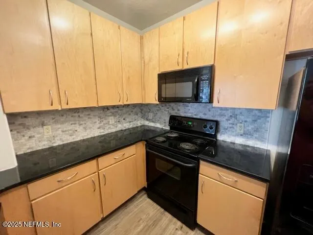 a kitchen with granite countertop cabinets stainless steel appliances and a counter space