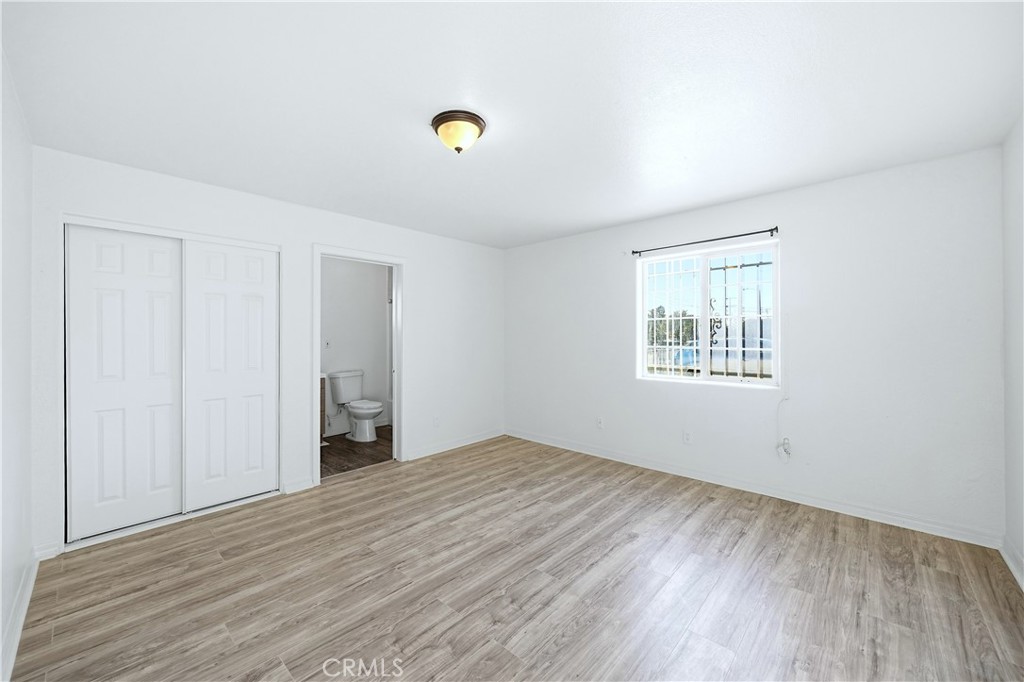 10929 Compton Avenue Los Angeles, CA 90059 - Photo 12 of 29 an empty room with wooden floor and windows