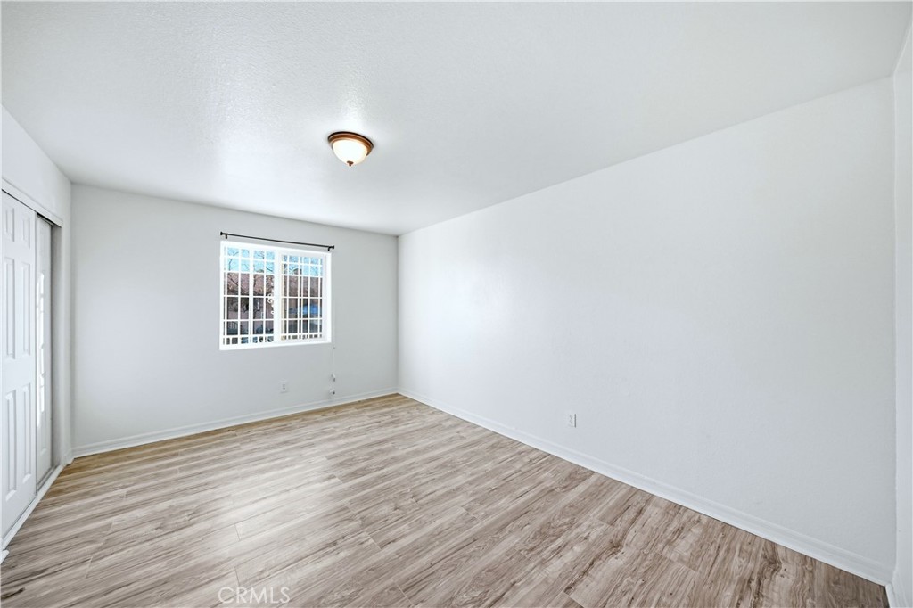 10929 Compton Avenue Los Angeles, CA 90059 - Photo 15 of 29 an empty room with wooden floor and windows