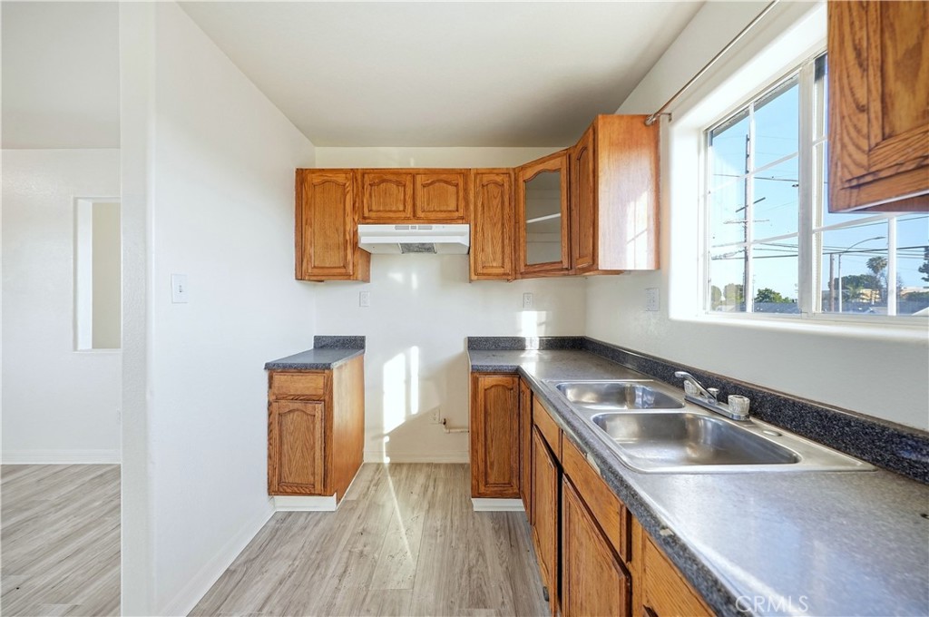 10929 Compton Avenue Los Angeles, CA 90059 - Photo 21 of 29 a kitchen with stainless steel appliances granite countertop a sink a stove and a wooden floors
