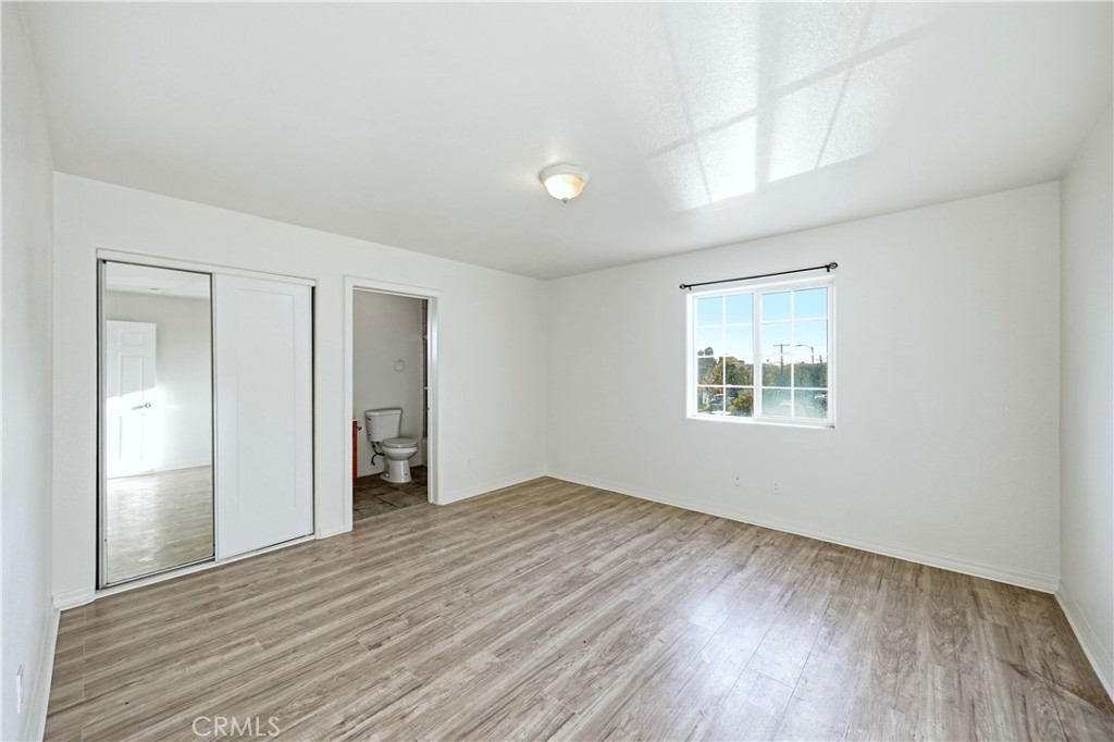 10929 Compton Avenue Los Angeles, CA 90059 - Photo 26 of 29 an empty room with wooden floor and windows