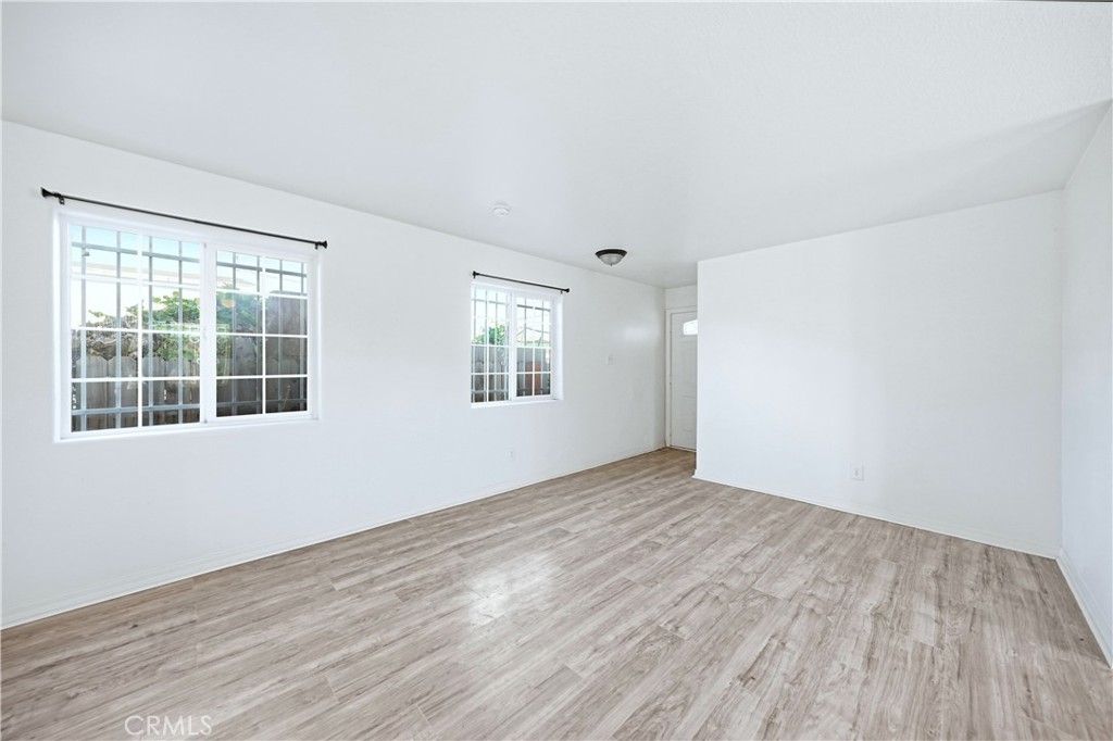 10929 Compton Avenue Los Angeles, CA 90059 - Photo 4 of 29 an empty room with wooden floor and windows