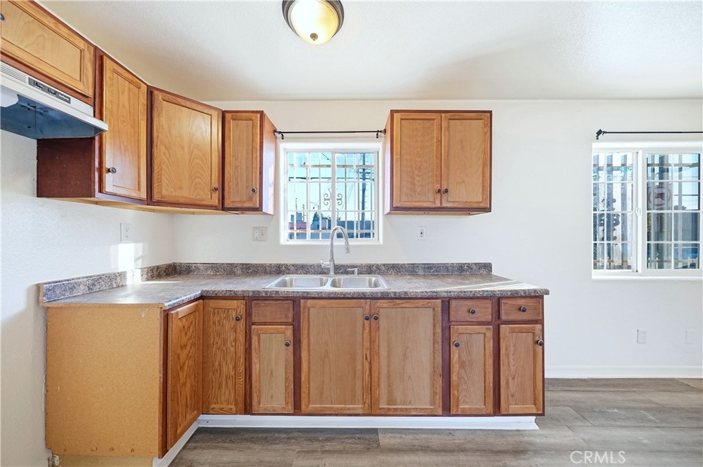 10929 Compton Avenue Los Angeles, CA 90059 - Photo 7 of 29 a kitchen with granite countertop a sink cabinets and wooden floor