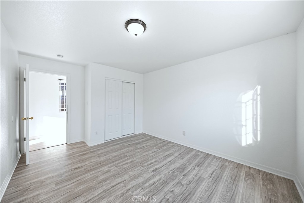 10929 Compton Avenue Los Angeles, CA 90059 - Photo 8 of 29 an empty room with wooden floor and windows