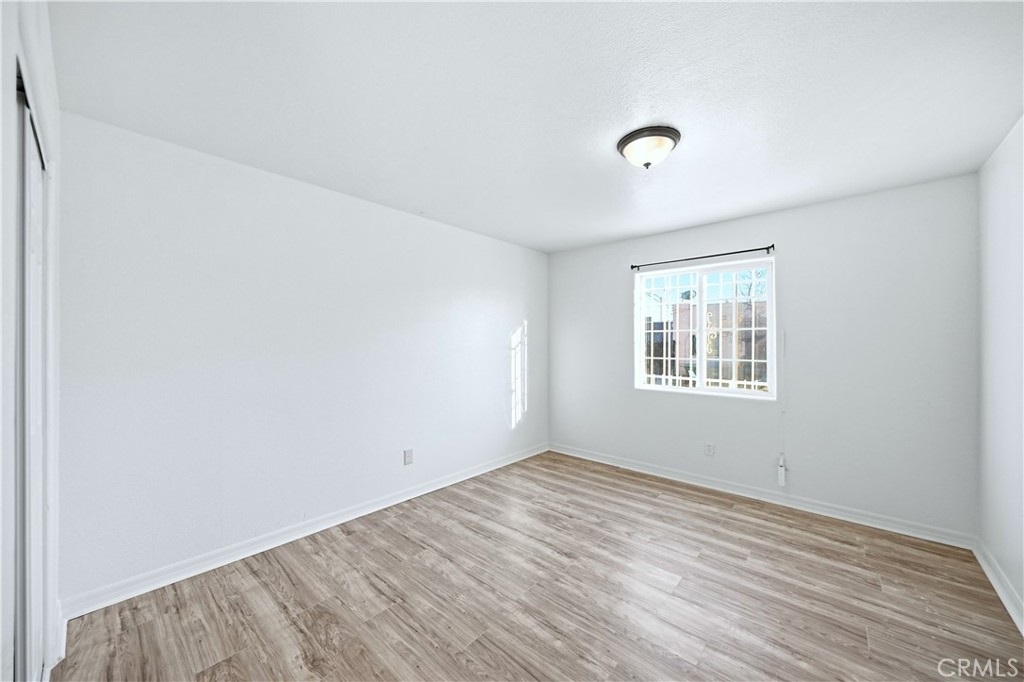10929 Compton Avenue Los Angeles, CA 90059 - Photo 9 of 29 an empty room with wooden floor and windows