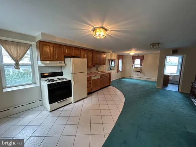 a kitchen with a refrigerator and a stove top oven