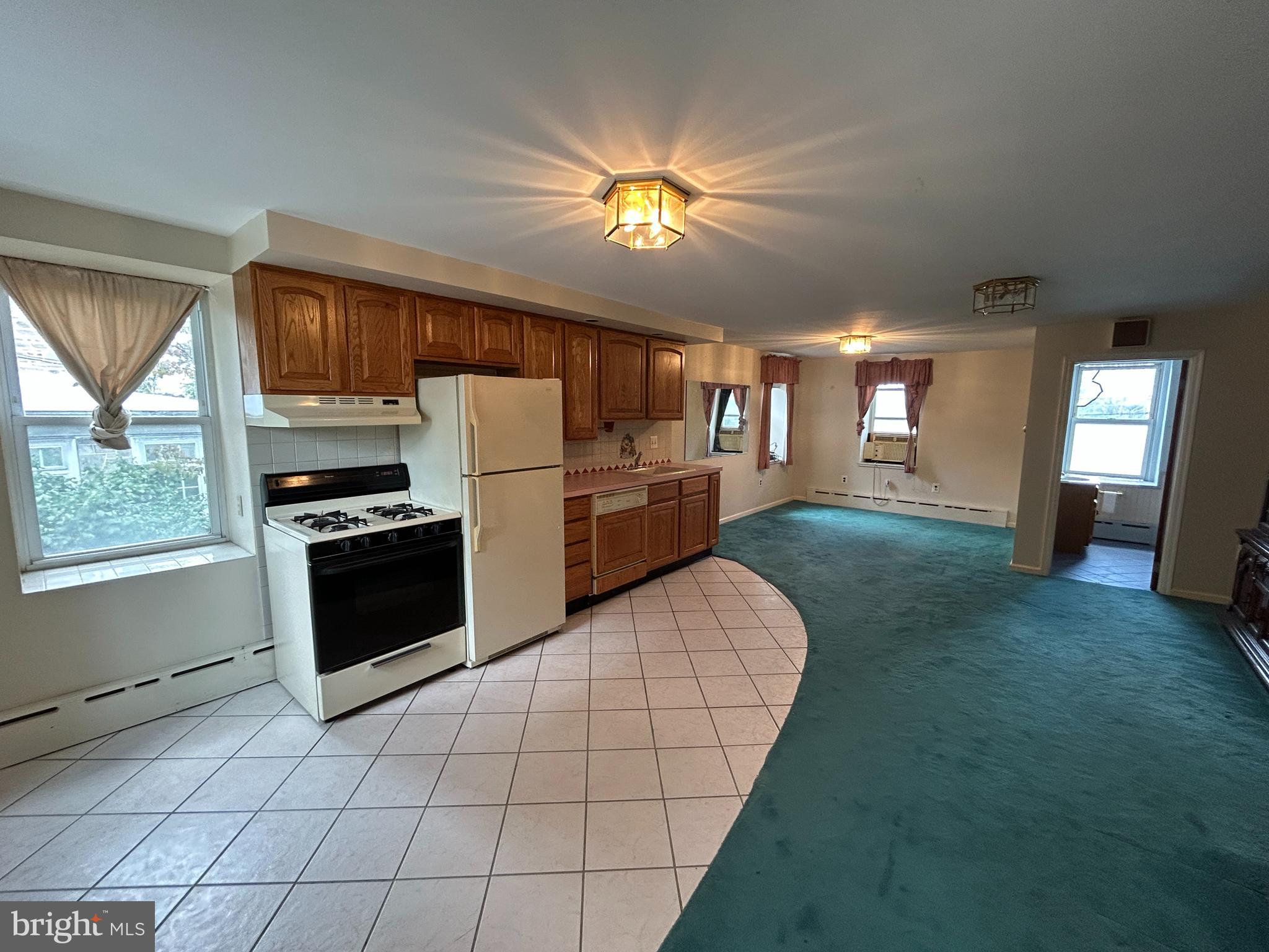 6502 Ridge Avenue, Unit 2 Philadelphia, PA 19128 - Photo 2 of 12 a kitchen with a refrigerator and a stove top oven
