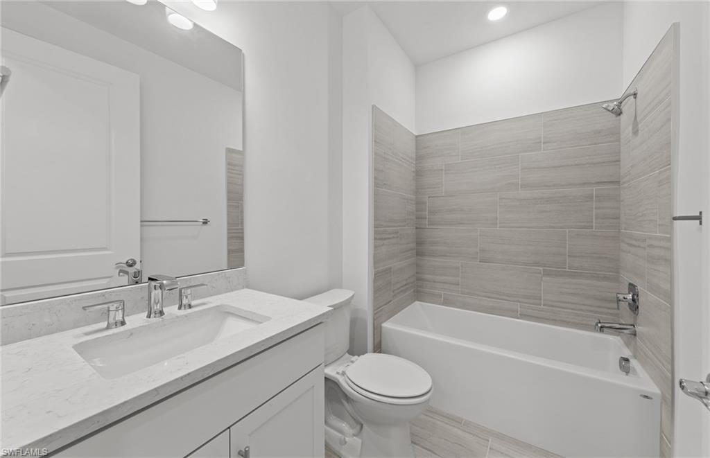 15707 Northridge Road Punta Gorda, FL 33982 - Photo 15 of 21 a bathroom with a granite countertop sink a toilet and bathtub