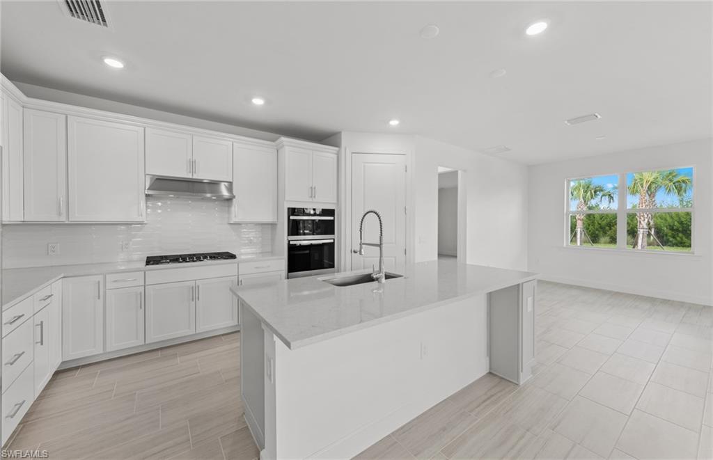 15707 Northridge Road Punta Gorda, FL 33982 - Photo 7 of 21 a kitchen with kitchen island white cabinets and refrigerator