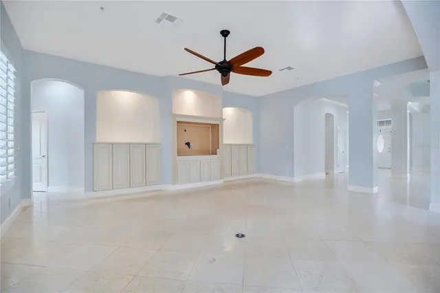 a view of an empty room with a ceiling fan and window