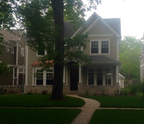 1304 Maple Avenue Wilmette, IL 60091 - Photo 1 of 1 a view of a brick house with a large windows and a yard with plants and large trees