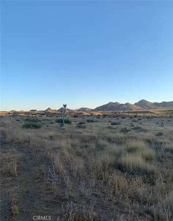 a view of mountain and grassy field