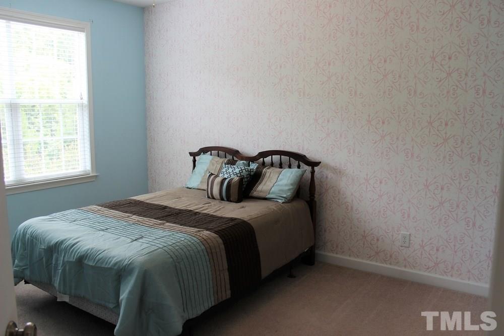7304 Caversham Way Raleigh, NC 27617 - Photo 17 of 22 a bedroom with a bed and window