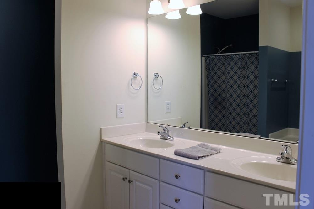 7304 Caversham Way Raleigh, NC 27617 - Photo 21 of 22 a bathroom with a sink and a mirror