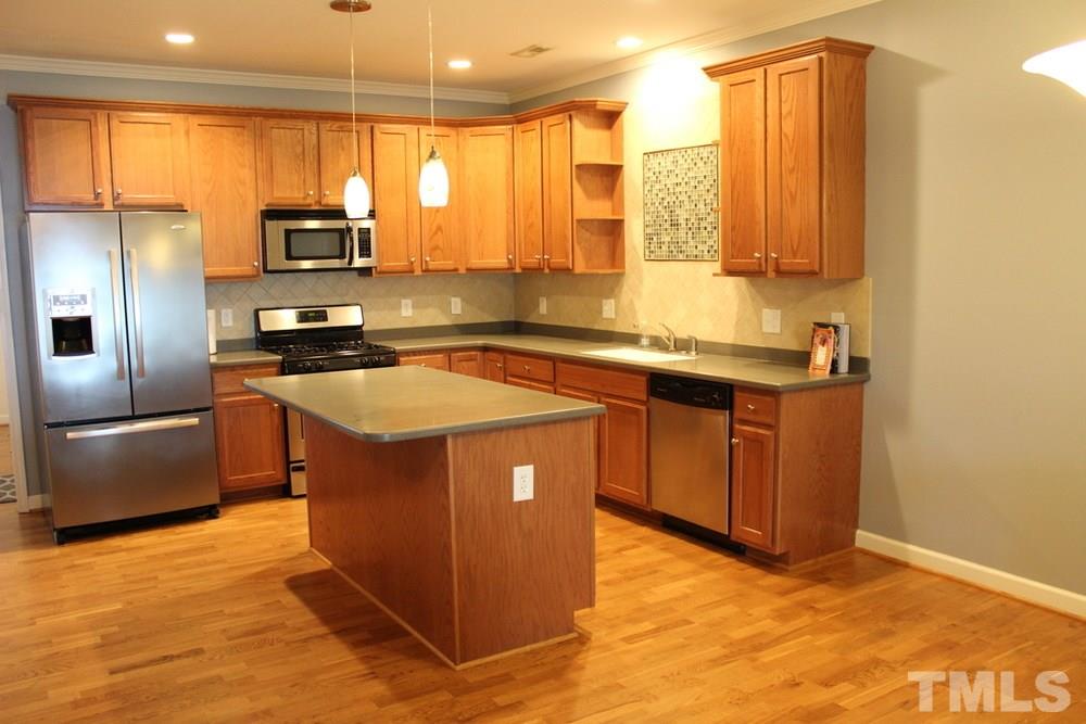 7304 Caversham Way Raleigh, NC 27617 - Photo 6 of 22 a kitchen with stainless steel appliances granite countertop a sink a stove and a refrigerator