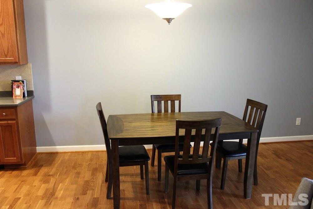 7304 Caversham Way Raleigh, NC 27617 - Photo 8 of 22 a view of a dining room with furniture and wooden floor