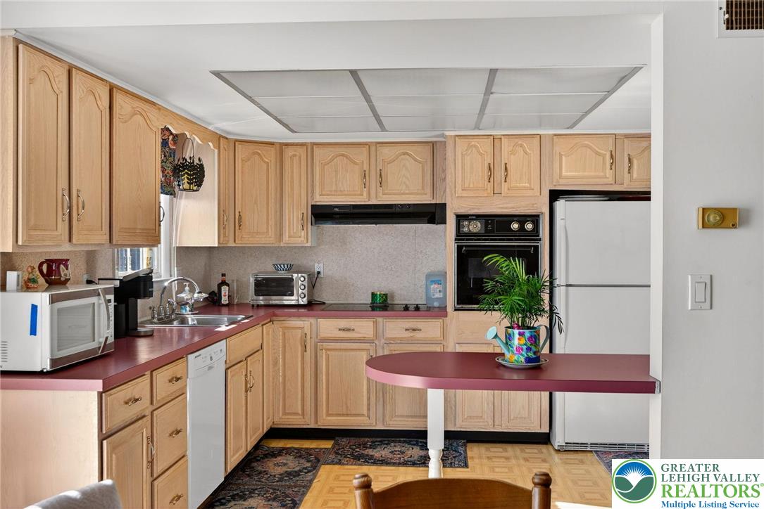 5424 Clauser Road Orefield, PA 18069 - Photo 13 of 31 a kitchen with stainless steel appliances granite countertop a sink a stove and cabinets