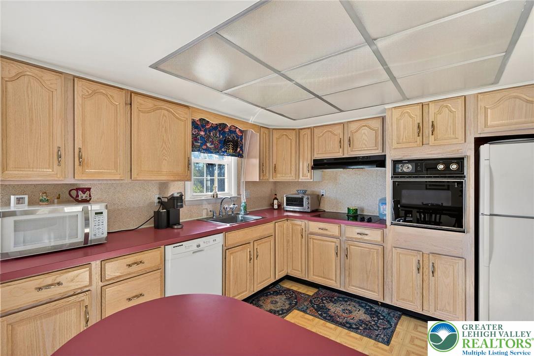 5424 Clauser Road Orefield, PA 18069 - Photo 14 of 31 a kitchen with stainless steel appliances a sink a stove a refrigerator cabinets and a window