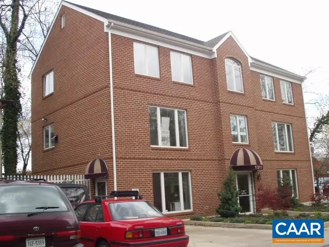 a front view of a building with parking space and a street