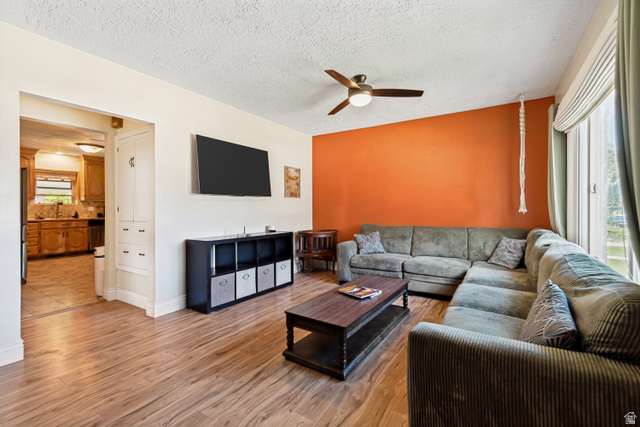127 West 300 North Springville, UT 84663 - Photo 7 of 24 Living area featuring wood flooring, a ceiling fan with integrated lighting, and a large window with blinds