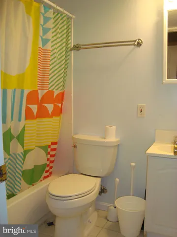 a bathroom with a toilet and a shower curtain