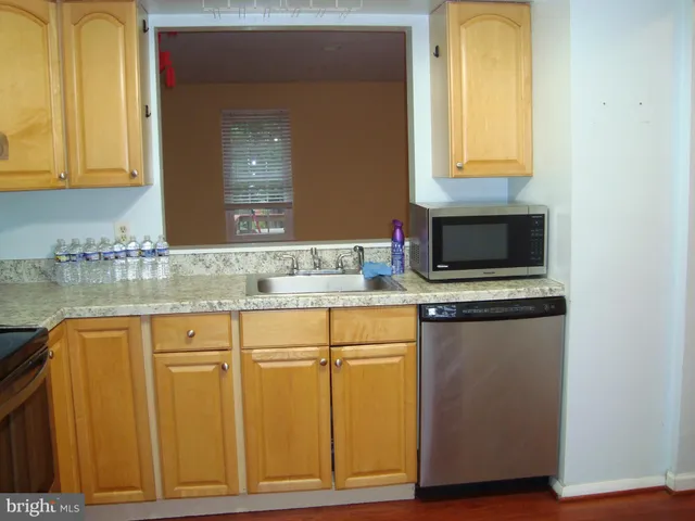 a kitchen with granite countertop cabinets stainless steel appliances and a sink