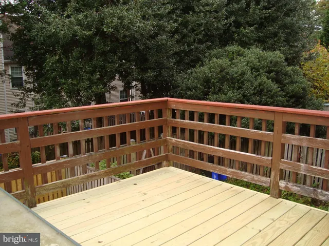 a view of a balcony with wooden floor and fence