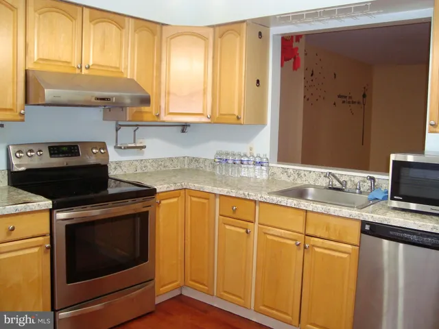 a kitchen with granite countertop cabinets stainless steel appliances and a sink
