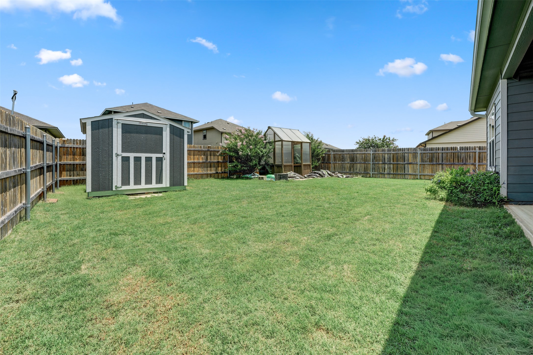 413 Perfect World Loop Jarrell, TX 76537 - Photo 37 of 39 A fenced yard provides ample green space and two outbuildings for storage or hobbies.