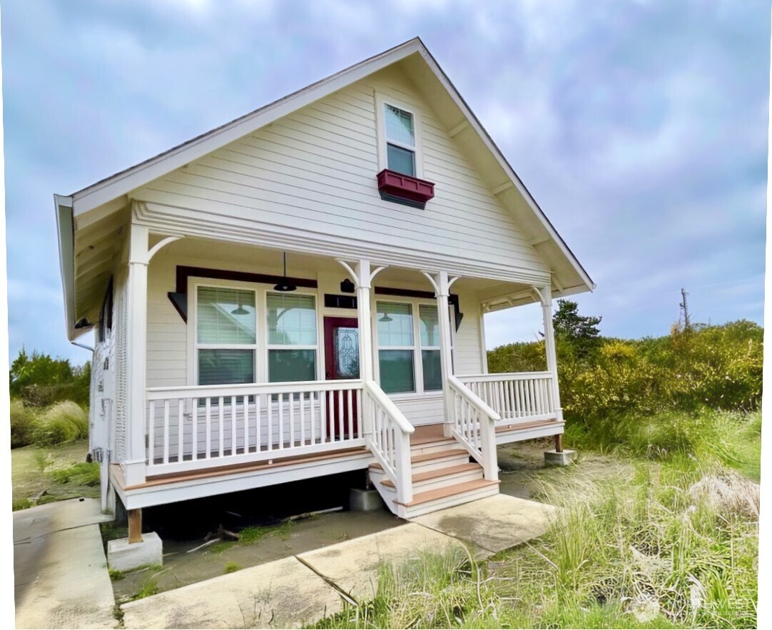 a view of a house with a wooden deck and furniture