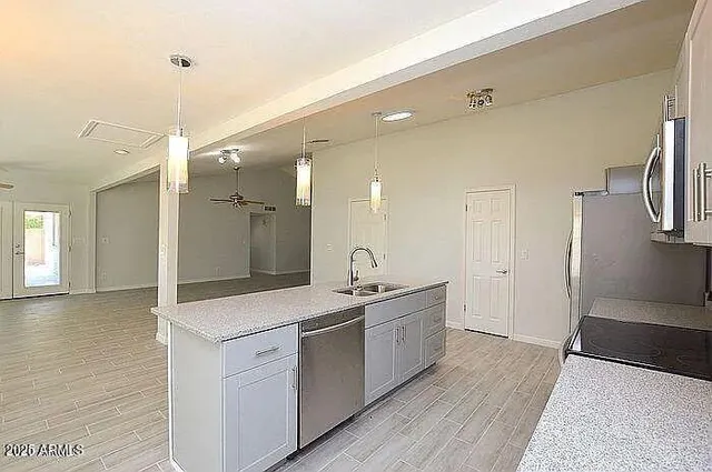 a spacious bathroom with a granite countertop sink a toilet a mirror and shower