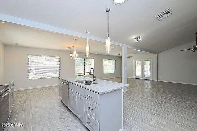 a kitchen with stainless steel appliances granite countertop a sink stove and wooden floor