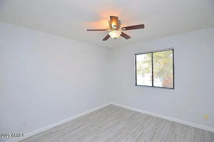 6431 East Sandra Terrace Scottsdale, AZ 85254 - Photo 10 of 19 an empty room with wooden floor fan and windows