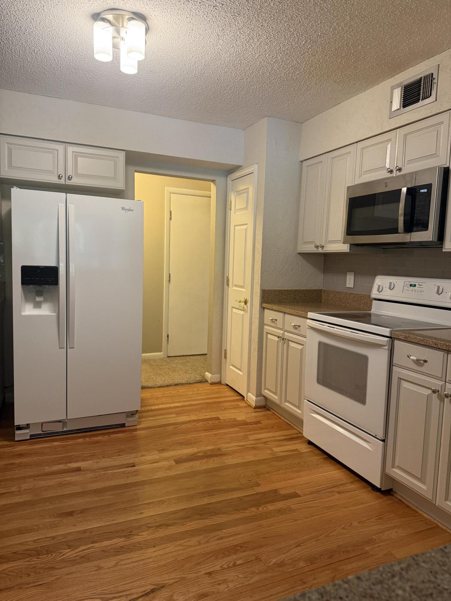 504 Main Street Destin, FL 32541 - Photo 16 of 25 a kitchen with stainless steel appliances white cabinets and wooden floor