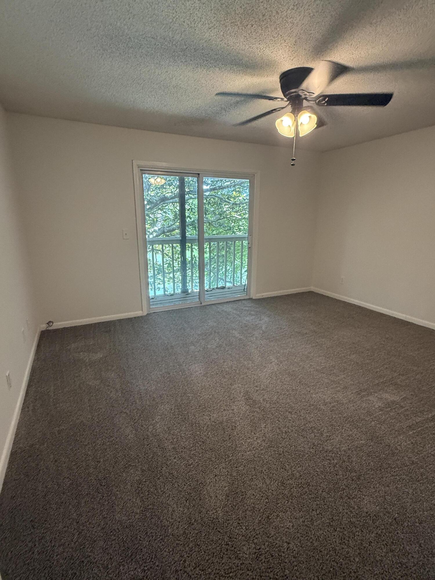 504 Main Street Destin, FL 32541 - Photo 21 of 25 an empty room with windows and chandelier fan