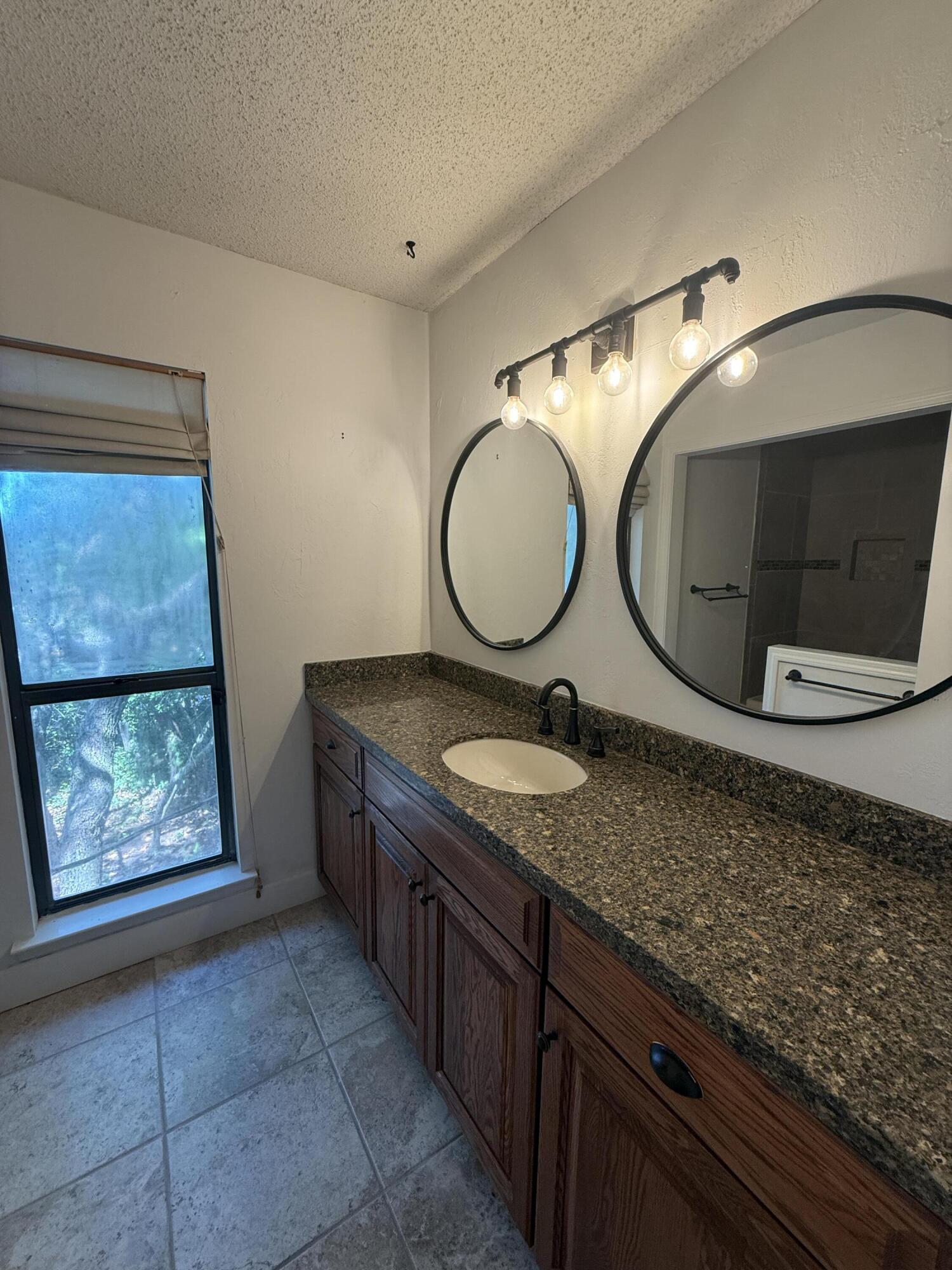 504 Main Street Destin, FL 32541 - Photo 24 of 25 a bathroom with a granite countertop sink and mirror
