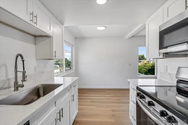 a kitchen with stainless steel appliances a sink stove and microwave