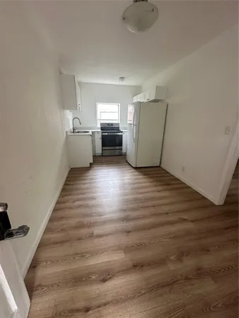 a view of a kitchen with wooden floor and electronic appliances