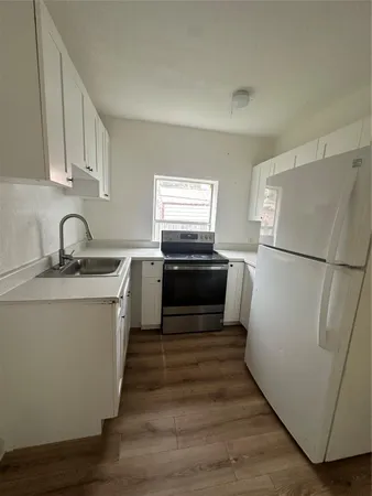 a kitchen with wooden floors and appliances
