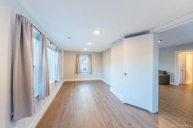 a view of a hallway with wooden floor and windows