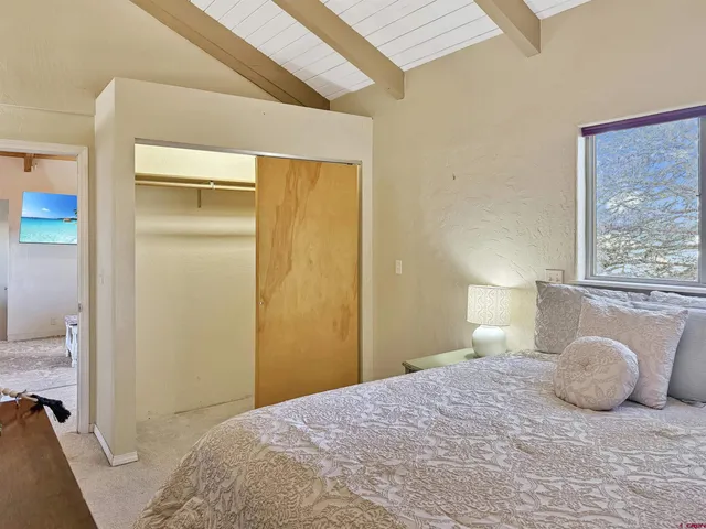 a bedroom with a bed and a painting on the wall