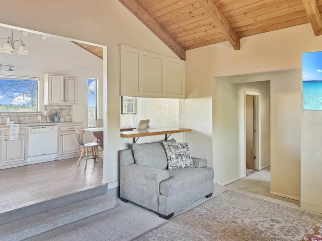 a living room with furniture and a dining table with kitchen view