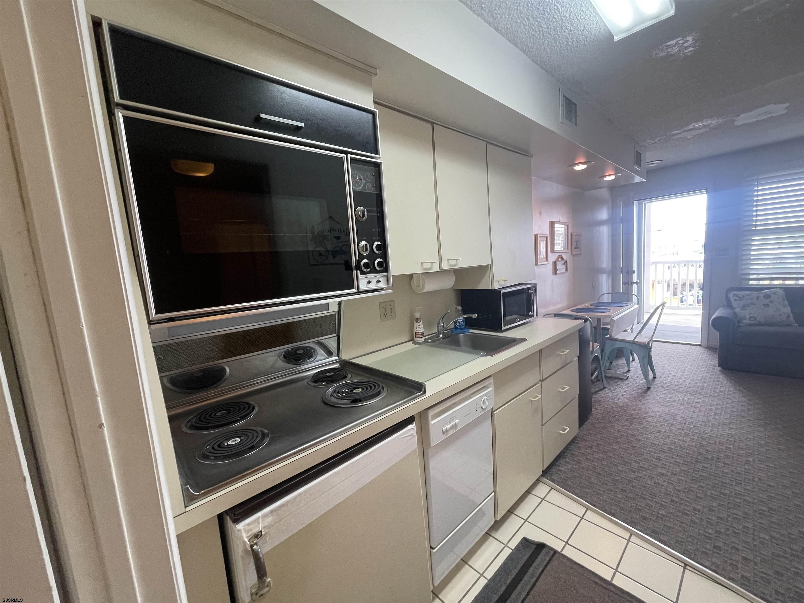 853-71 Plymouth Place, Unit 13 Ocean City, NJ 08226 - Photo 3 of 6 a kitchen with a stove and a microwave