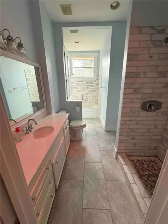 a bathroom with a sink a toilet and mirror